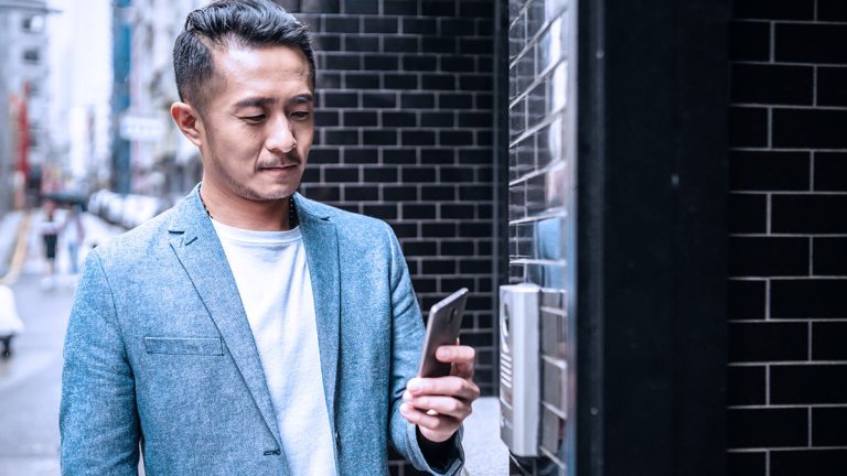 hwt_person_using_smartphone_to_open_front_door